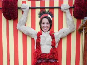 Rachel laughing, her face through a seaside strongman cutout board with red and white stripes.